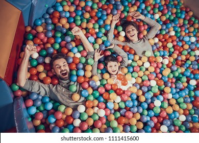 Top View. Happy Family Lying In Pool With Balls. Family Rest, Leisure Concept. Spending Holiday Together. Entertainment Center, Mall, Amusement Park.