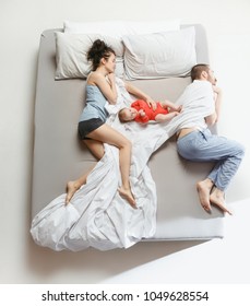 Top view of happy funny family with one newborn child in bedroom. Enjoying being together. Happy family in bed. Top view. Emotions concept. Morning after sleep. Family lifestyle. happy parents concept
