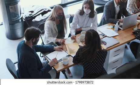 Top View Happy Multiethnic Creative Start-up Business People Wear Masks Working At Meeting At Light Modern Office Table.