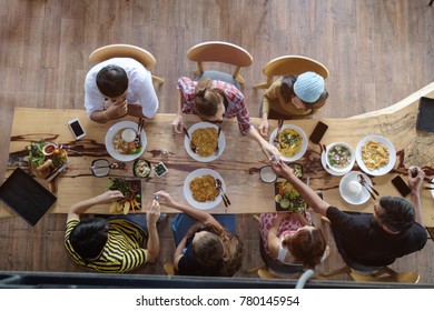 Top View Of Happy People Gathering For Eating Food Together And Enjoying The Party And Communicate With Family And Friends At Table On Holiday, Soft Focus Background