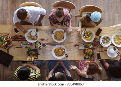 Top View Of Happy People Gathering For Eating Food Together And Enjoying The Party And Communicate With Family And Friends At Table On Holiday, Soft Focus Background