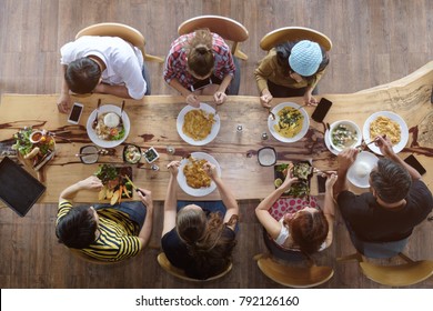 Top View Of Happy People Gathering For Eating Food Together And Enjoying The Party And Communicate With Family And Friends At Table On Holiday, Soft Focus Background