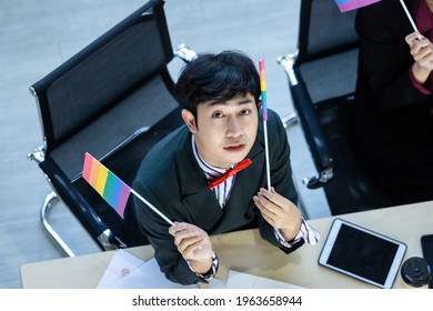 Top View Happy Of Smiling Homosexual Asian Businessman LGBT With LGBT Flag Working At Laptop Computer And Business People Group In The Meeting Room At Modern Office