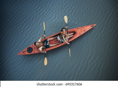 Top View Of Happy Young Couple In Sea Vests Sailing A Kayak