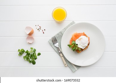 Top View Of Healthy Breakfast With Poached Eggs Royale (benedict), Fresh Orange Juice And Green Salad