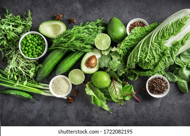 Top view of healthy organic food: green vegetables, seeds and herbs on dark background. Source of protein for vegetarians.