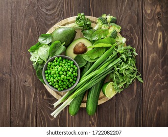 Top view of healthy organic food: green vegetables and herbs on dark wooden background. Source of protein for vegetarians. - Powered by Shutterstock