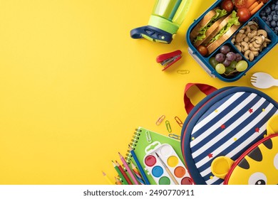 Top view of a healthy school snack with a lunchbox, kid's bag, and school supplies on a yellow background - Powered by Shutterstock