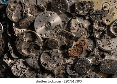 Top View Of Heap Of Metal Internal Parts Of An Old Clock. Silver Clockwork With Gears And Cogwheels. Rusty Aged Vintage Watch Parts. Disassembled Clock Mechanism Of Vintage Clock. Close Up.