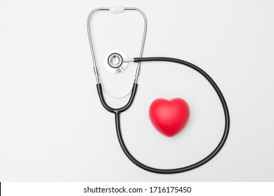 Top View Of Heart Shaped Squeeze Ball For Hand Muscle Exercise And Stethoscope On White Background