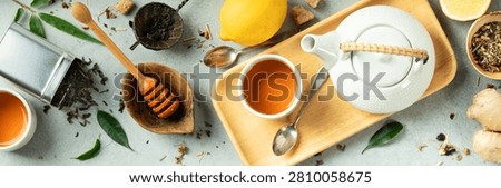 Top view of herbal tea, ginger, lemon, honey, and natural spa items on a light surface. A clean, modern flat lay for wellness, holistic living, and healthy lifestyle themes.