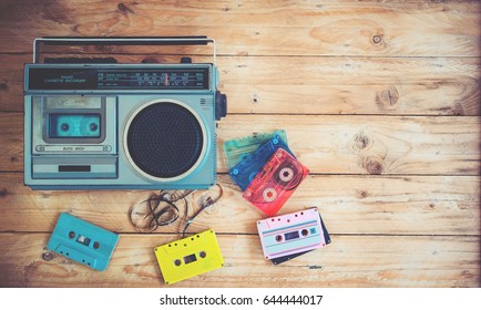 Top view hero header - retro technology of radio cassette recorder music with retro tape cassette on wood table. Vintage color effect styles. 