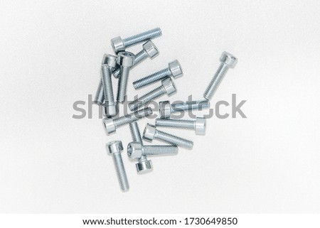 Top view of hexagon socket Bolts. Pile of stainless steel bolts on bright white background with silver color with copy space. 3d illustration