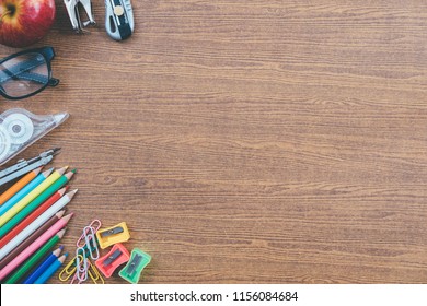 Top View High Angle Back To School Still Life On Top Of A Wood Teachers Desk, Note Pads, Pencils And Erasers With Copy Space Flat Lay.