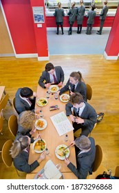 Top View Of High School Students In Uniforms Eating Lunch At The Cafeteria.