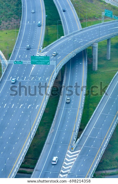 Top view of\
highway road with green grass\
below