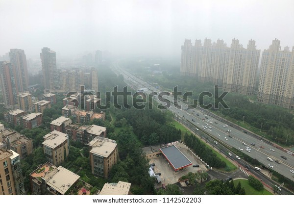 Top view highway with severe air pollution,\
fog and haze in Beijing city, China. Air pollution is a serious\
problem in Beijing, China, 2018, July\
10