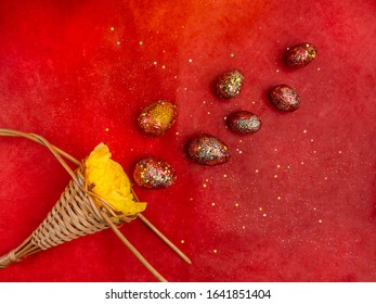 Top view of holiday card with gold red eggs, wicker basket with festive glitter confetti on a red background. Happy easter concept, copy space - Shutterstock ID 1641851404