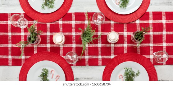 Top View Of Holiday Table With Red Checked Table Runner Decorated For Christmas