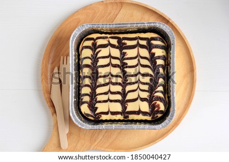 Top View Homemade Cream Cheese Brownies with Beatiful Swirl Motifs on Top. Bake on Square Alumunium Foil Baking Dish 