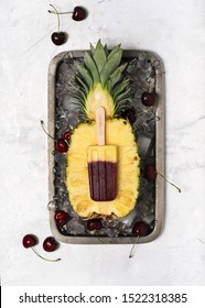 Top View Of Homemade Frozen Popsicle With Fresh Pineapple And Cherries On Metal Tray Full Of Ice Cubes. Summer Dessert.