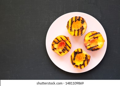 Top View, Homemade Grilled Peaches On A Pink Plate On A Black Surface. Flat Lay, Overhead, From Above. Copy Space.