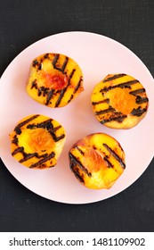 Top View, Homemade Grilled Peaches On A Pink Plate On A Black Background. Flat Lay, Overhead, From Above. Close-up.