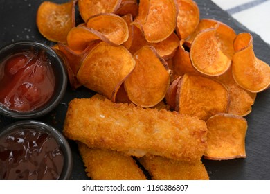 Top View Homemade Organic Baked Fried Sweet Potatoes Chips And Fish Fingers Served Home Made Tomato Sauce And Barbecue Sauce On Black Slate Plate, Healthy Snack For Family Concept