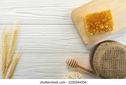 Top View Of Honey Comb And Glass Honey Jar On Wooden White Background