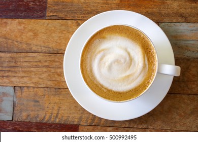 Top View Of Hot Coffee Cappuccino Cup With Milk Foam On Wood Table Background