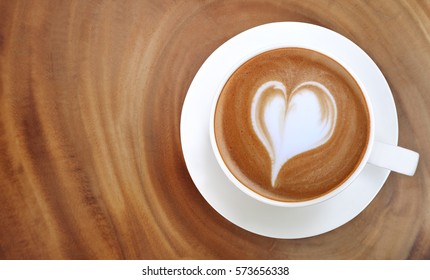 Top View Of Hot Coffee Latte Art Heart Shape Foam On Wood Table Background