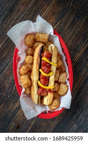 Top View Hot Dog In Toasted Bun With Tater Tots In Basket