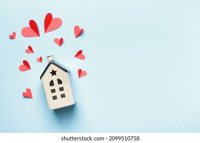 Top View Of A House With Paper Hearts On A Blue Background. Love Valentines Day Holiday Family Wedding Real Estate Construction Life