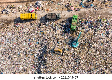 Top view of A Huge Waste, garbage, dump, rubbish landfill. A landfill compactor, group of workers sort out the garbage in the landfill. Trash trucks dump waste polluting products.