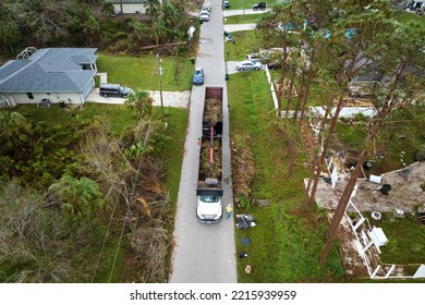 Top View Of Hurricane Ian Special Aftermath Recovery Dump Truck Picking Up Tree Branches Debris From Florida Rural Streets. Dealing With Consequences Of Natural Disaster