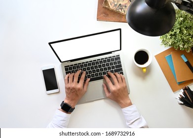 Top View Image Of Businessman's Hand Typing On White Blank Screen Computer Laptop That Putting On White Working Desk With Office Equipment. Orderly Workplace Concept.