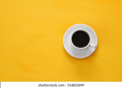 Top view image of coffe cup on wooden yellow background. Flat lay. Copy space - Powered by Shutterstock