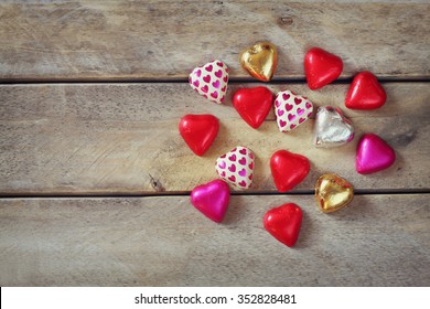 top view image of colorful heart shape chocolates on wooden table. valentine's day celebration concept - Powered by Shutterstock