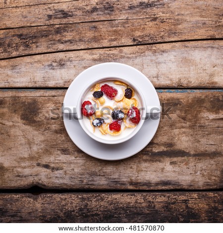 Top view image of corn flakes with raspberry and mulberry breakfast background.