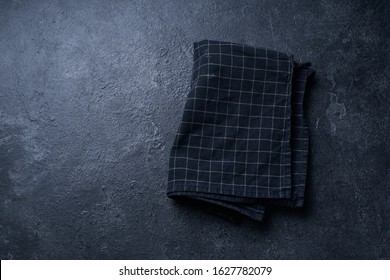 Top View Image With Dark Textured Kitchen Table And Black Checkered Cotton Towel. Flatlay With Copy Space                               