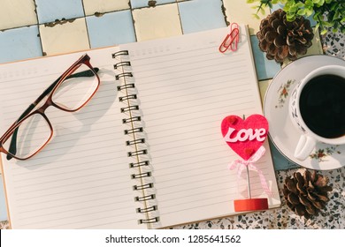Top view image of empty notebook,spectacles and cup of coffee on Marble floor background. Love concept with heart desktop,Valentine's Day.