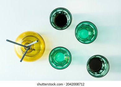 Top view image of green glasses and a yellow vase on white background
