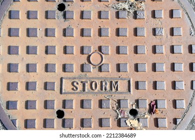 A Top View Image Of A Large Metal Storm Drain Cover.