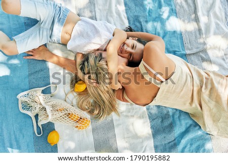 Similar – Two women with sunglasses smiling lying in blanket