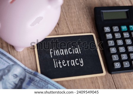 Top view image of piggy bank, calculator and money with text FINANCIAL LITERACY. 