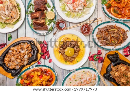 Top view image of popular Chinese dish set of orange duck, tres delicias rice with prawns, fried ribs, sweet and sour pork, beef with bamboo and mushroom shiitake