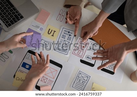 Top view image of a professional and creative UX UI graphic designer team voting a perfect prototype for their new product, discussing and planning work in the meeting.