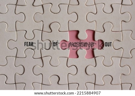 Top view image of puzzle with text FEAR OF MISSING OUT or FOMO. 