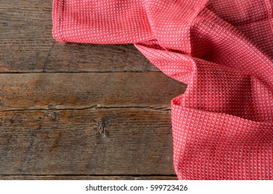 A Top View Image Of A Red And White Tea Towel On A Wooden Kitchen Table.