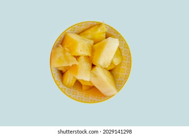 Top View Image Of Ripe Pineapple Chunks Inside A Yellow Bowl